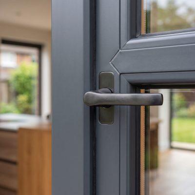 Modern flush handle hardware on a premium anthracite grey uPVC window, showcasing contemporary design details.